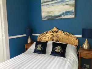 拉姆斯盖特Paragon Home的一间卧室配有一张蓝色墙壁的床
