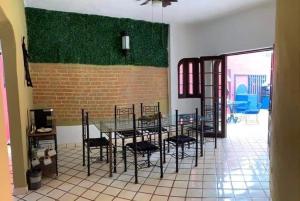 巴亚尔塔港VILLA OASIS的一间设有桌椅和砖墙的用餐室