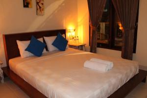 库塔赤林库塔民宿的一间卧室配有一张带蓝白色枕头的大床