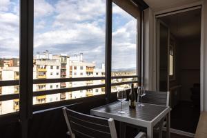 卢布尔雅那Elegant 1-bedroom apartment near hill forest的观景阳台的桌子和酒杯