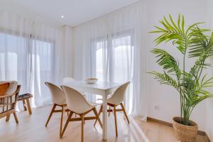 塔维拉FormosaTavira Seaview @Homesbyfc的白色的用餐室配有白色的桌椅