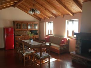 克雷米亚Chalet Buonriposo的厨房以及带桌子和红色冰箱的客厅。