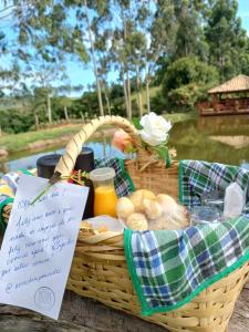 南蒙蒂阿莱格里Pousada Erva Doce的野餐篮,包括面包和果汁及标志