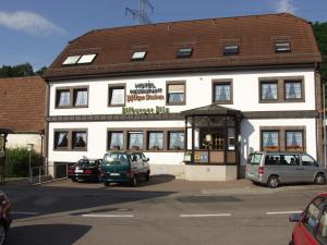 Bruchmühlbach-MiesauHotel-Restaurant-Pfaelzer-Stuben的一座白色的建筑,前面有汽车停放