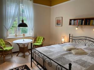 普特布斯Villa Schulenburg in Putbus auf Rügen的卧室配有一张床和一张桌子及椅子
