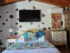圣卢西亚Romantic Casa Rural La Molinera的卧室配有一张床,墙上挂有绘画作品