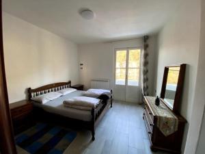 波尔托瓦尔特拉瓦利亚Casa vacanze Porto Valtravaglia Lago Maggiore的一间卧室配有两张床、一个梳妆台和镜子