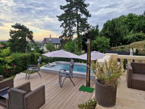 布吉瓦尔la source de bougival的一个带遮阳伞和椅子的庭院和一个游泳池