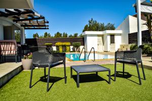 拉纳卡Ilios Villa的一个带桌椅的庭院和一个游泳池