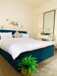 马达巴Laura's Cozy HOME的一间卧室配有一张大床和植物