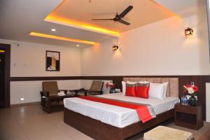 达尔瓦德M R Residency Dharwad.的一间卧室配有一张大床和吊扇