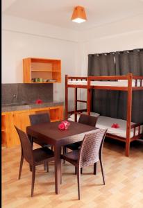 卢纳将军城Siargao Sunrise Villa的客房设有桌椅和一张双层床。