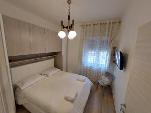 塔兰托Da Enza的一间小卧室,配有一张白色的床和一个吊灯