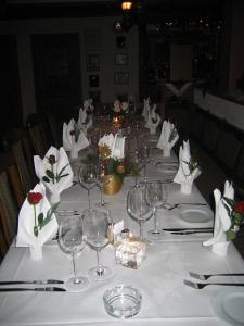 Bruchmühlbach-MiesauHotel-Restaurant-Pfaelzer-Stuben的长桌,带酒杯和鲜花