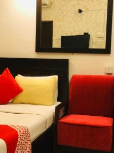 科伦坡OYO MotelVIP的酒店客房,设有两张床和一张红色椅子