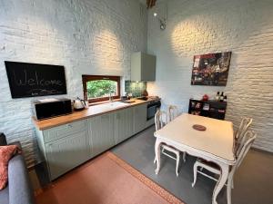 KraainemCosy little house的厨房配有桌子、水槽和台面