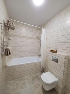 捷尔诺波尔VINNA Просторі апартаменти в новобудові.的带浴缸、卫生间和浴缸的浴室。