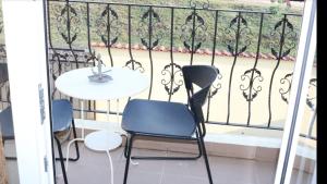 巴克乌VLAD&ELISA的阳台配有两把椅子和一张桌子,位于栏杆上