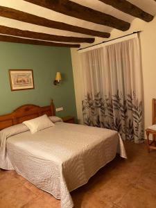 别尔赫CASA RUFAS (Sierra de Guara)的一间卧室设有一张大床和一个窗户。