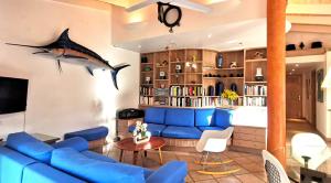 博尼法乔樂拉岡-威旬禄瑟别墅的客厅配有蓝色沙发和墙上的鲨鱼