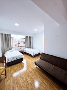 MancosHuascarán Inn的一间带两张床和一张沙发的客厅