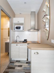 居让梅斯特拉Le Studio de Noreda的厨房配有白色橱柜和水槽