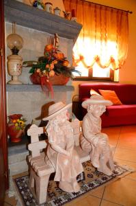米罗B&B Dimora dell' Etna的客厅里两座长椅上的人的雕像