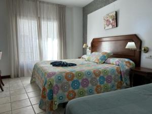 托罗克斯安达卢斯酒店的酒店客房设有两张床和窗户。