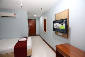 吉隆坡LA ISRA at KL的一间卧室配有一张床,墙上配有电视