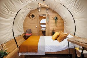 布泽乌河畔瓦马乡Glamping Spiritul Zimbrului的帐篷内的卧室,配有一张床