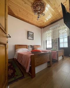 ErsekëAs e vogël, As e madhe的一间卧室设有一张床和木制天花板