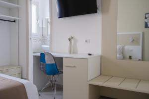 波萨达VeMi Affittacamere的白色卧室配有书桌和蓝椅