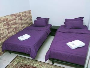 关丹Kuantan Homestay Best Facility Wifi BBQ Viu的配有两张床铺的宿舍间提供紫色床单和毛巾