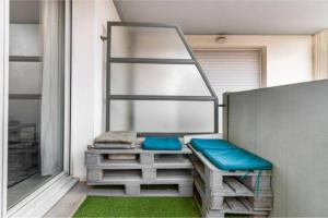 图卢兹Appartement T2 40 m2 - Tout équipé et calme的阳台设有长凳和绿草窗户。