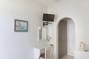 迈加洛丘里The Milos的白色的客房设有书桌和墙上的电视。