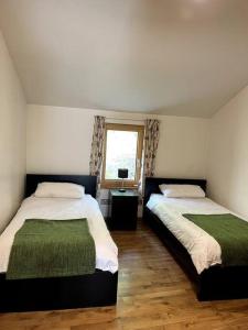 BallyorganBallyhoura Forest Home的一间卧室设有两张床和窗户。