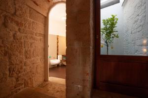 阿尔贝罗贝洛Le Alcove - Luxury Hotel nei Trulli的走廊上设有门和盆栽