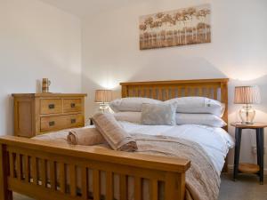 SouthamNo 2, The Stables的一间卧室配有一张带枕头的大型木制床。