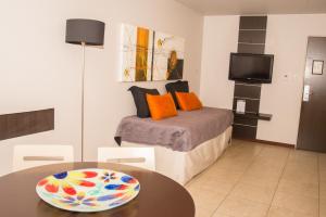 科尔多瓦库贝快捷公寓的一间卧室配有一张带桌子的床和一台电视。