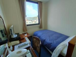 犬山市Inuyama City Hotel的客房设有床、书桌和窗户。