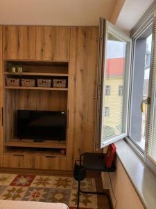 科希策Nové bývanie v centre Košíc.的客厅配有电视、椅子和窗户