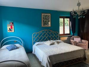 TravedonaIl gufo e il gatto del lago的蓝色卧室配有两张床和椅子