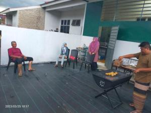 关丹Kuantan Homestay Best Facility Wifi BBQ Viu的一群人坐在甲板上,烤架