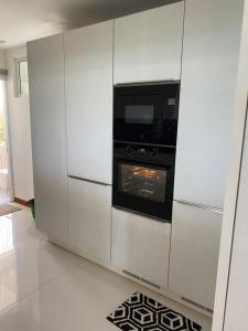 亭可马里Luxury Penthouse, Nilaveli的厨房配有白色橱柜和烤箱。