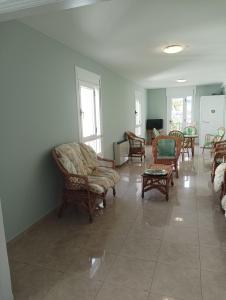 波尔托马林Hotel Villa Jardín的铺有瓷砖地板,设有带桌椅的客厅。