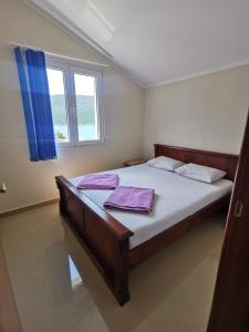 赫尔采格诺维Apartmani Krivokapic的一间卧室配有一张带紫色床单的床和窗户。
