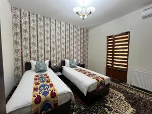 布哈拉OLD SAFARI HOTEL make yourself at home的一间卧室设有两张床和窗户。