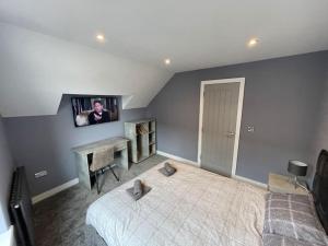布里德灵顿Penthouse Costa Del Brid的卧室配有一张床,墙上配有电视。
