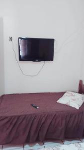 马里利亚Hotel Casa Grande Max的挂在床上方墙上的平面电视
