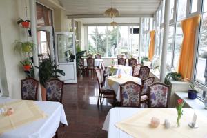 奥斯赛拜-屈隆斯博恩Hotel Poseidon的用餐室设有桌椅和窗户。